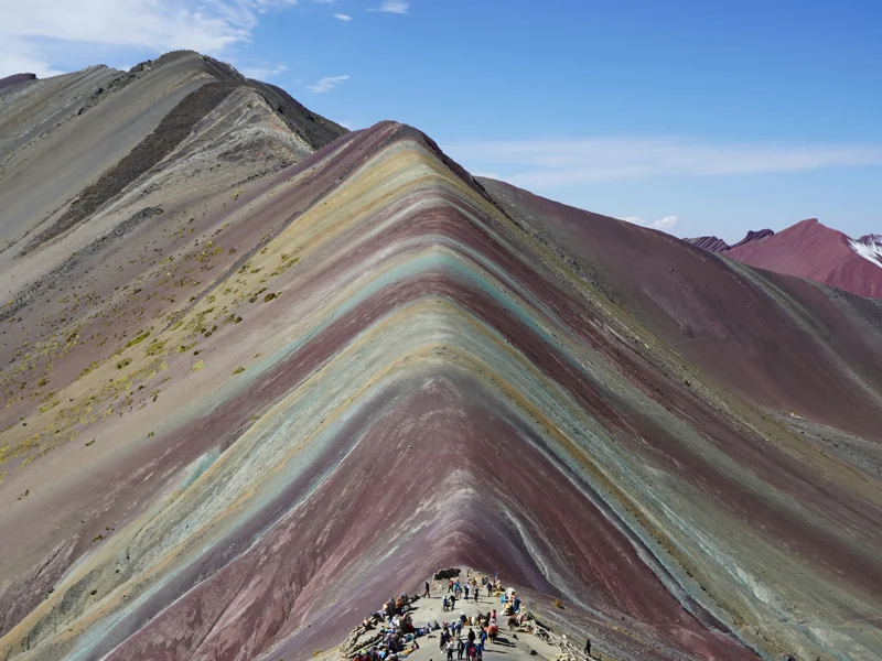 Rainbow Mountain Vinicunca colourful slopes with hikers at sunrise